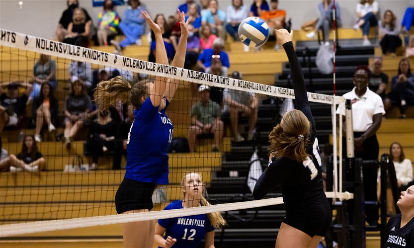 High school students play volleyball